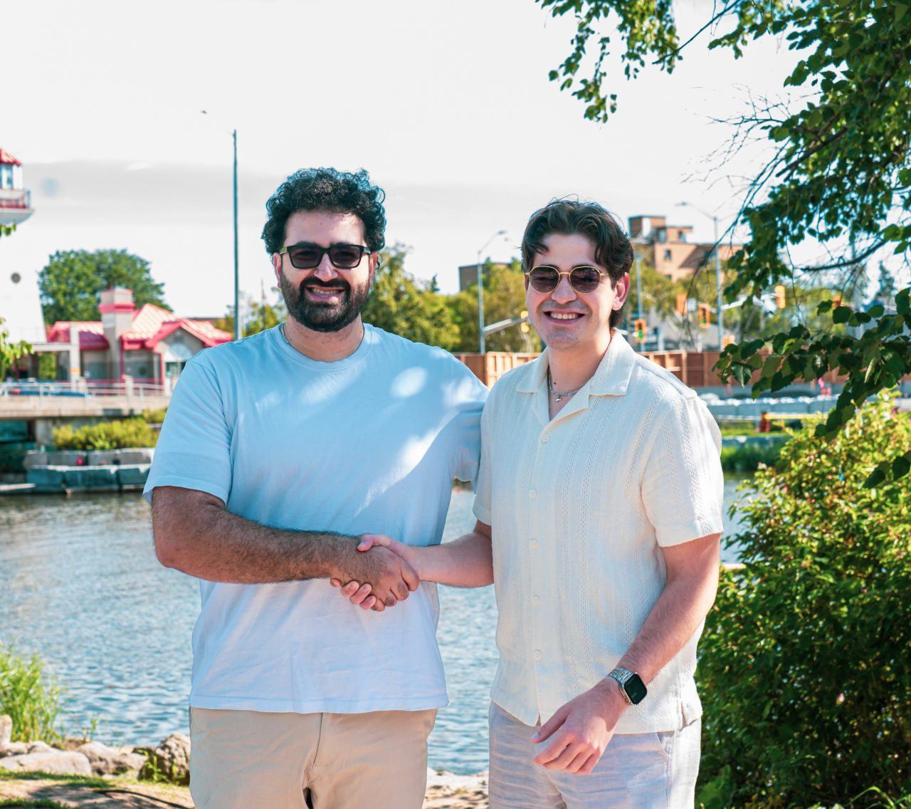 Jad El Ghali shaking hands with a community member beside the Port Credit waterfront